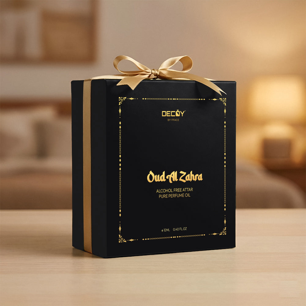 Black perfume box with gold ribbon and text on a blurred background