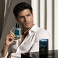 Man holding a Declyn perfume bottle with a white shirt and a neutral background