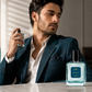 Man in a suit applying perfume with a Del Mar cologne bottle on a table.