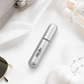 Silver cylindrical container with 'Decoy' branding on a white surface with sunglasses and a perfume bottle.