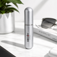 Silver cylindrical container with 'DECOY by FACE' branding on a light surface with sunglasses and a plant in the background.