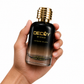 Hand holding a black and gold Decoy by Fface perfume bottle on a white background