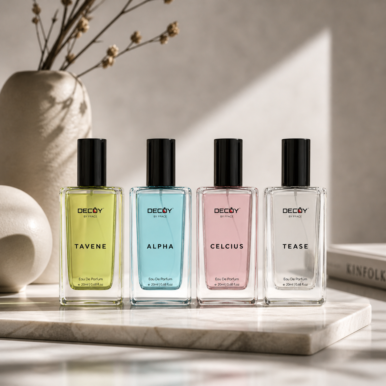 Four Decoy perfume bottles on a marble surface with a neutral background