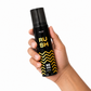 Hand holding a black and yellow 'Rush' deodorant can against a white background